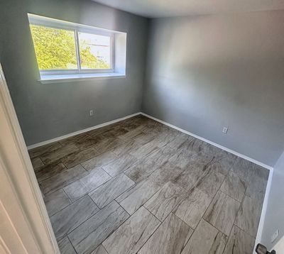 Bedroom with window and plank floor in a 2-bedroom Metairie home