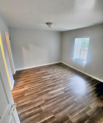 Bedroom with plank floor and window in a 1-bedroom New Orleans East home